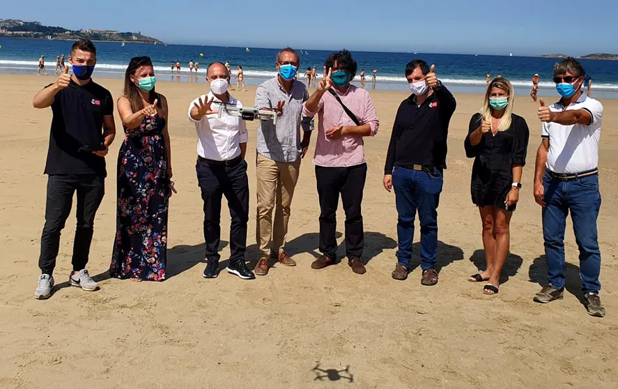 El delegado de Zona Franca, el alcalde y concejales de Nigr&aacute;n y  los representantes de la empresa DGH, en playa Am&eacute;rica con el dron de control de aforos.