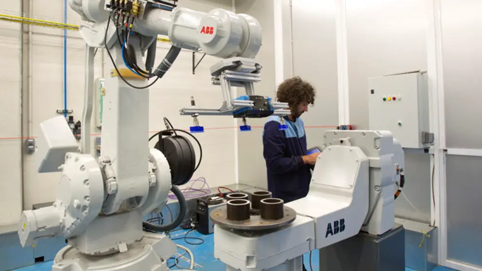 T&eacute;cnico trabajando con un robot antropom&oacute;rfico de seis ejes.