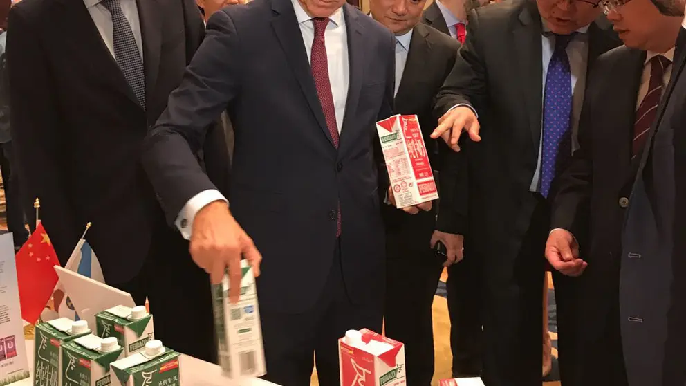 El conselleiro de Econom&iacute;a y el presidente de la Xunta ense&ntilde;an envases de leche gallega a los invitados chinos del Galician Gourmet Extravaganza.