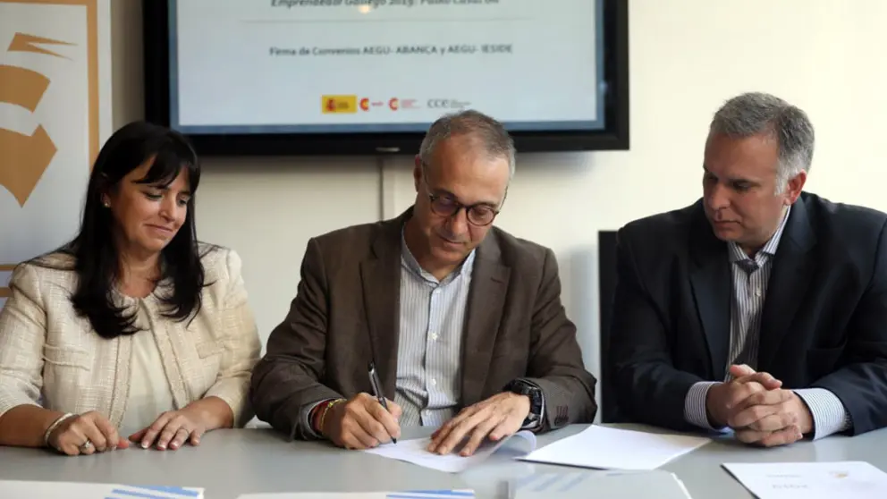 Los representantes de AEGU con el director de No residentes de Abanca, , en la firma del convenio.
