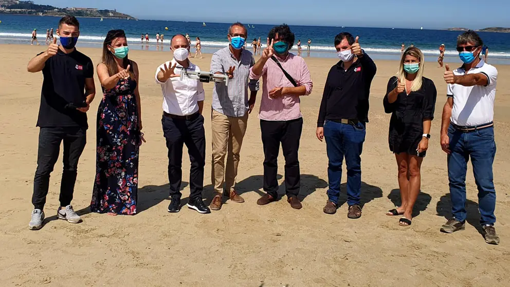 El delegado de Zona Franca, el alcalde y concejales de Nigr&aacute;n y  los representantes de la empresa DGH, en playa Am&eacute;rica con el dron de control de aforos.