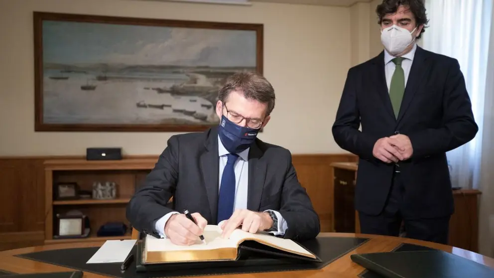 N&uacute;&ntilde;ez Feij&oacute;o firmando en el libro de honor de la Autoridad Portuaria de A Coru&ntilde;a en presencia de su presidente, Mart&iacute;n Fern&aacute;ndez.