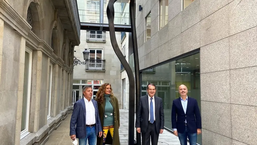 Andr&eacute;s Conde, Carmela Silva, Abel Caballero y David Regades junto a la escultura "El abrazo", a las puertas de la nueva sede de Zona Franca.
